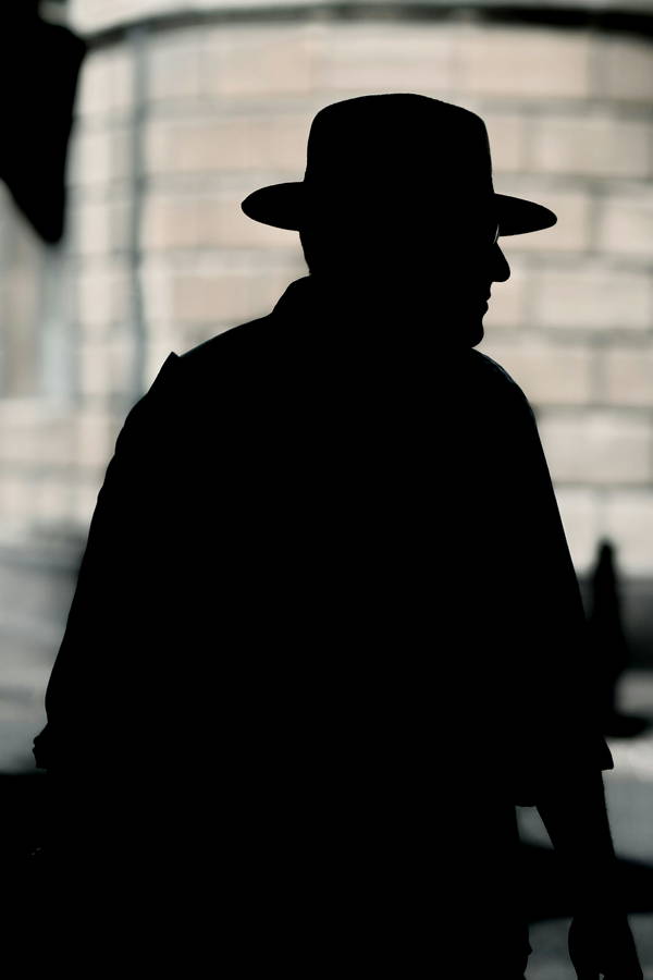 Silhouette of a man wearing a classic Fedora hat. 